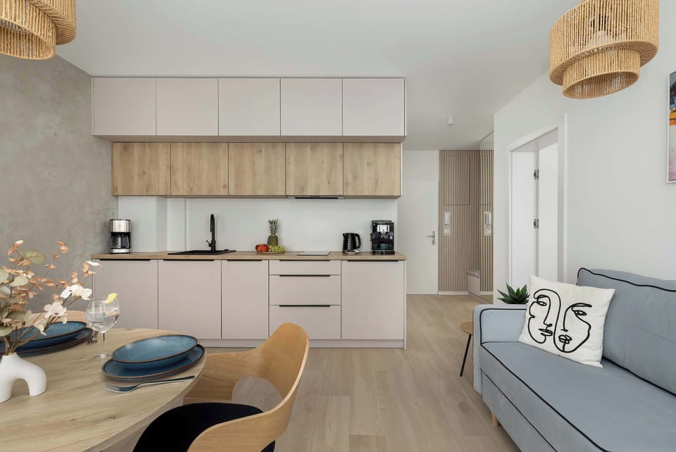 A view of the open-plan living area from the kitchen side, displaying the dining table set with elegant tableware and the lounge zone.