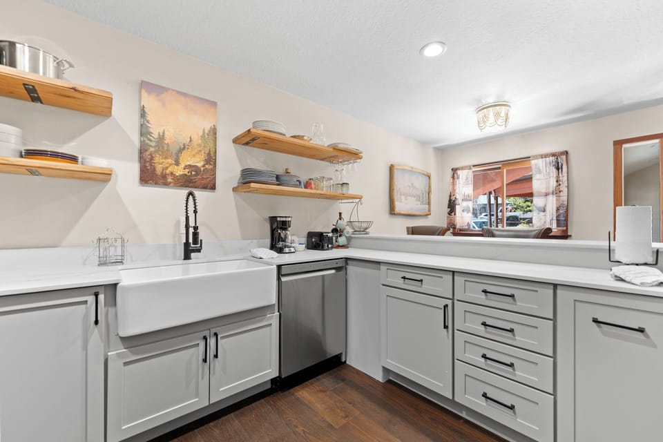 Full kitchen featuring stainless steel appliances, TV, and breakfast bar.