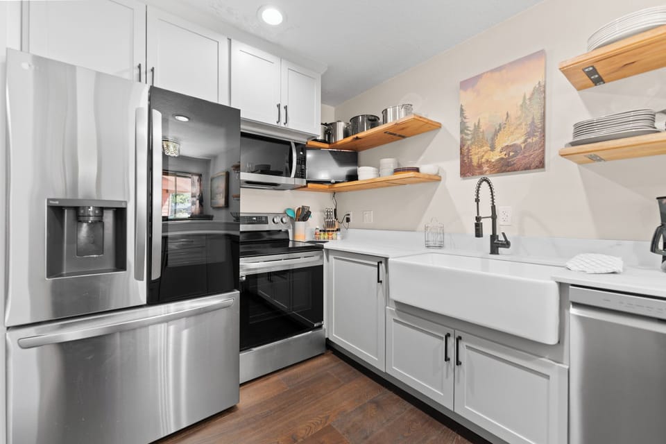 Full kitchen featuring stainless steel appliances, TV, and breakfast bar.