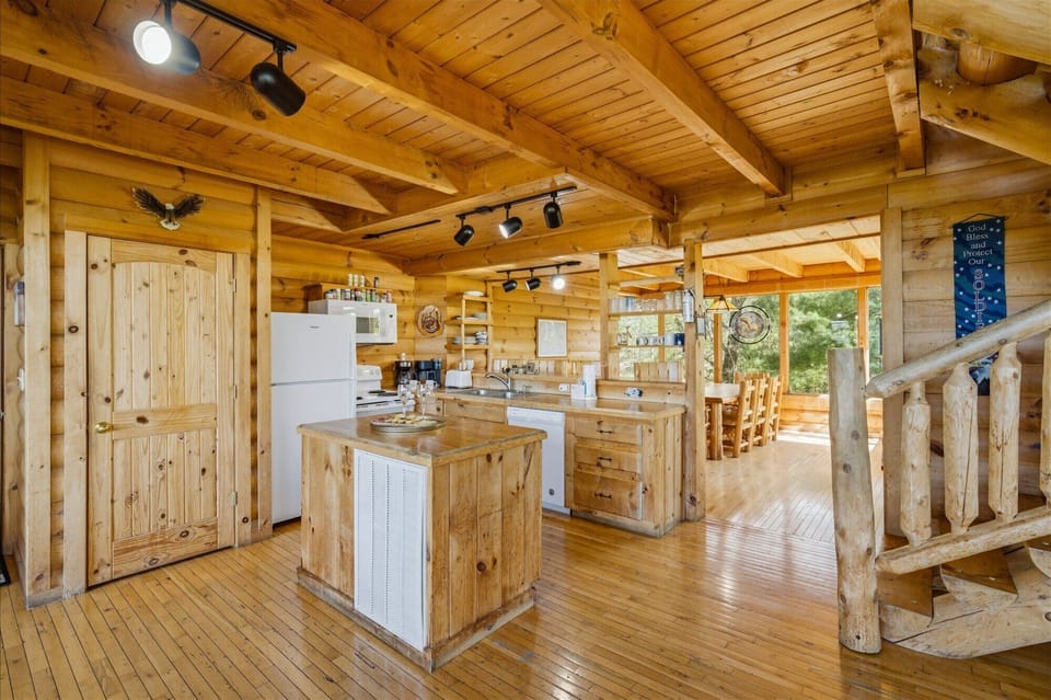 Gather in this stunning log cabin kitchen where warm wood surrounds you and rustic beams create cozy charm for memorable meals together.