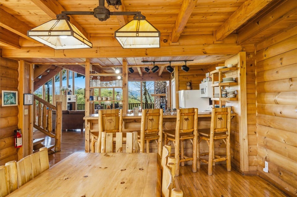 Warm logs embrace your mountain retreat's kitchen where handcrafted stools invite morning coffee and evening gatherings.