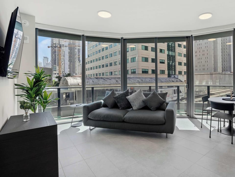 Bright living area with floor-to-ceiling windows and city views.