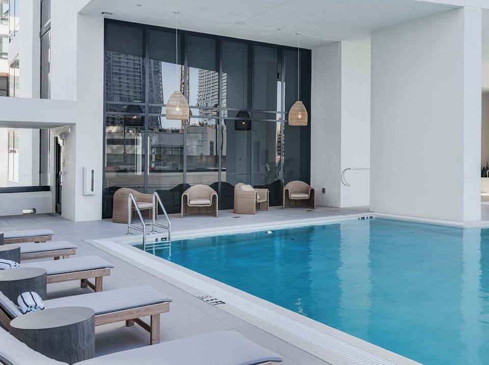 Indoor pool oasis with lounge chairs, modern design & city skyline views