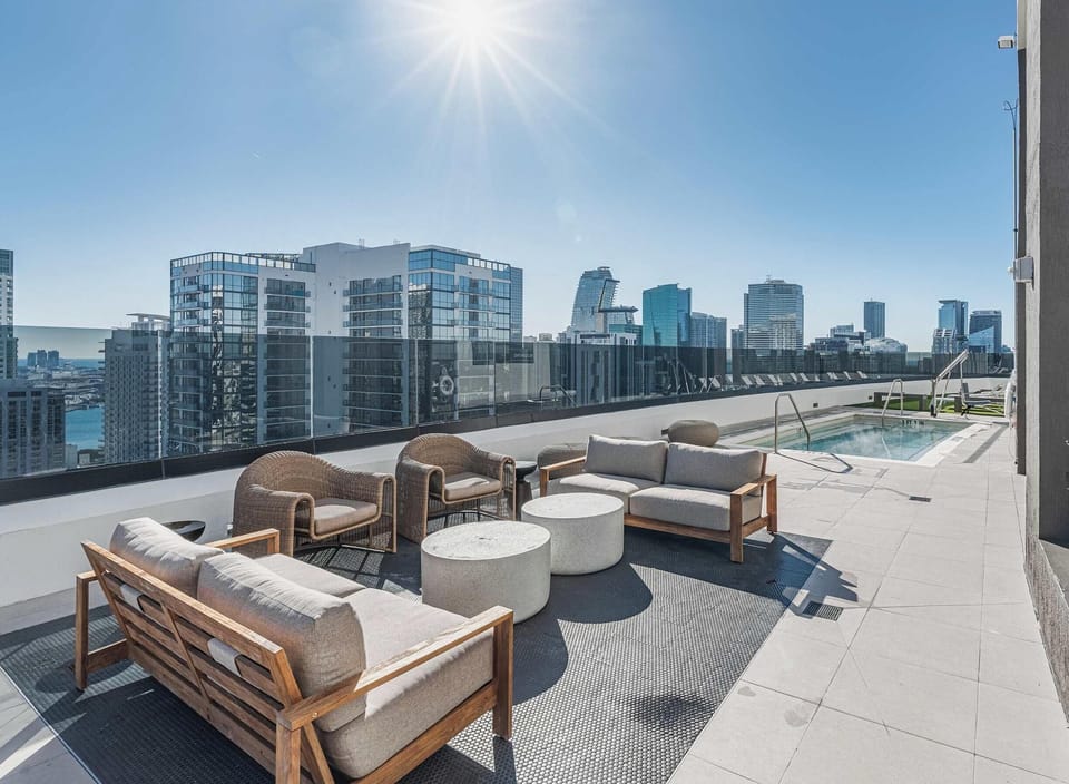 Sun-soaked rooftop lounge with sectional seating and panoramic city vistas
