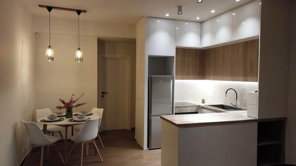 The kitchen is properly equipped: dark countertops, built-in appliances, and counter seating that doubles as a casual dining spot when you don't want to be too formal about it.