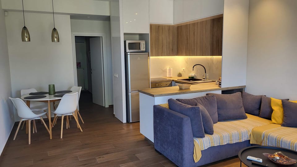 A view of the living and dining area together, showing how the space flows between the sofa, the round table, and the kitchen — open-plan without feeling cavernous.