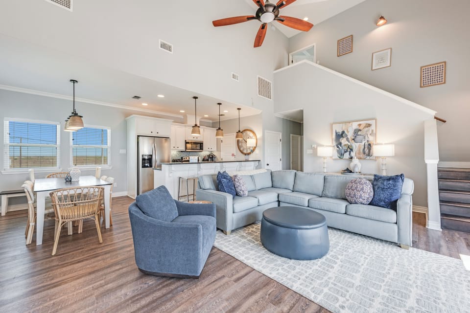Relax in your stylish open-concept retreat featuring soaring ceilings, modern kitchen, and comfortable seating perfect for memorable gatherings.