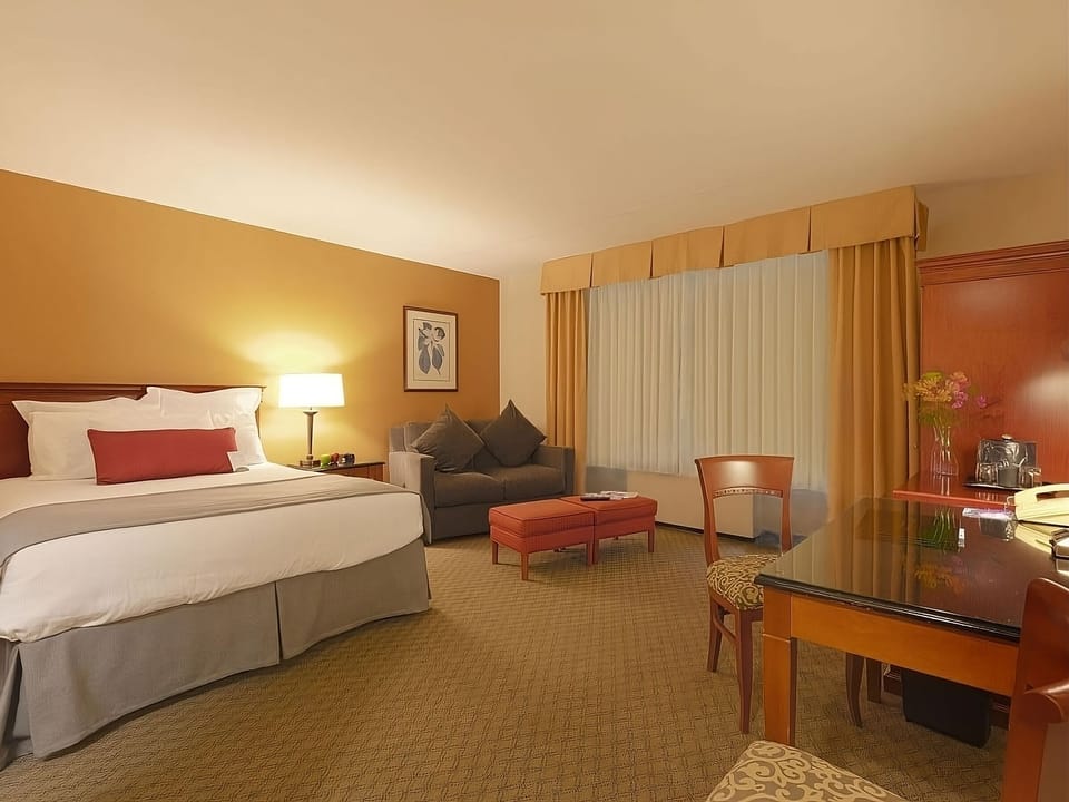 Unwind in a spacious suite with cozy seating and soft light.