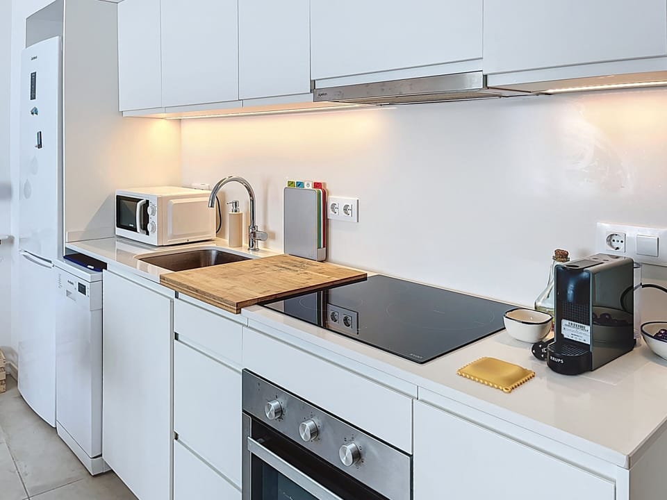 Modern kitchen with dishwasher, oven, and Nespresso coffee machine.