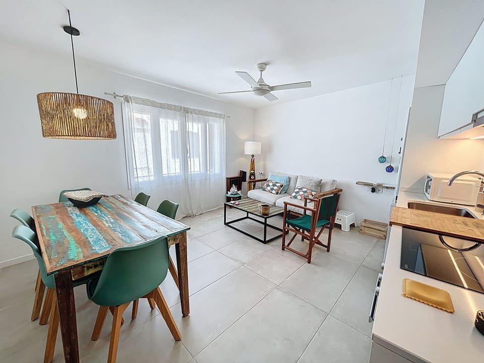 Open space with dining table, comfy sofa and fully equipped kitchen.