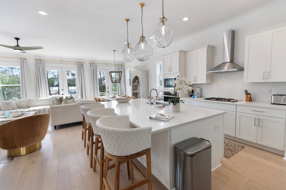 You'll love cooking in this bright, modern kitchen with sleek white cabinets, granite countertops, and stylish pendant lighting over the spacious island.