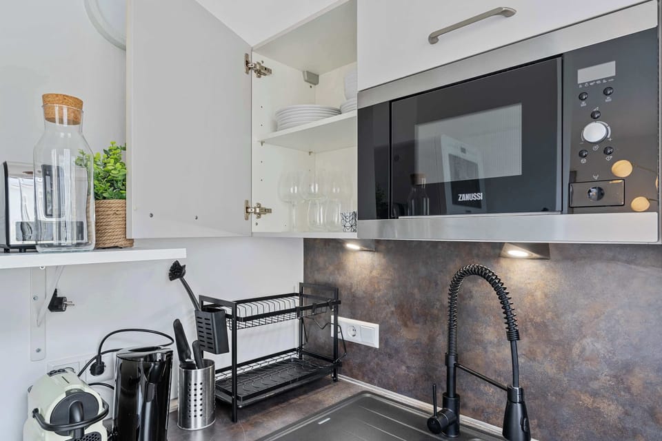 Modern kitchen details with sleek finishes, coffee setup, and all cookware needed to enjoy meals at home