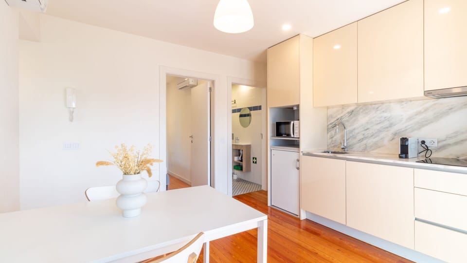 Whip up delicious meals in this sleek, fully-equipped kitchen featuring modern cabinetry and a convenient dining area, perfect for enjoying leisurely breakfasts or intimate dinners right at home.