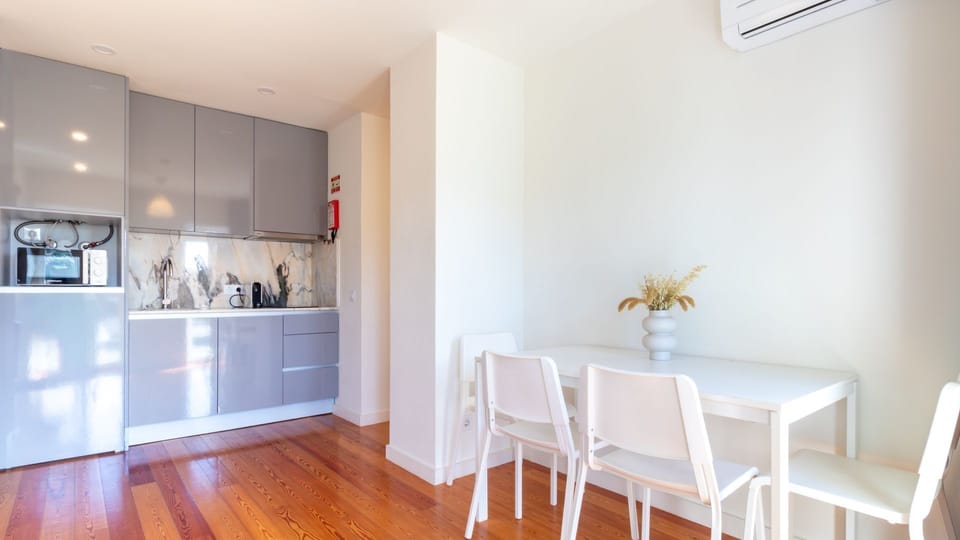 Prepare delicious meals in the sleek, modern kitchen equipped with all essentials, and then gather around the bright dining table for a wonderful meal. This space is designed for both culinary enjoyment and shared moments. #ModernKitchen #DiningArea #Slee
