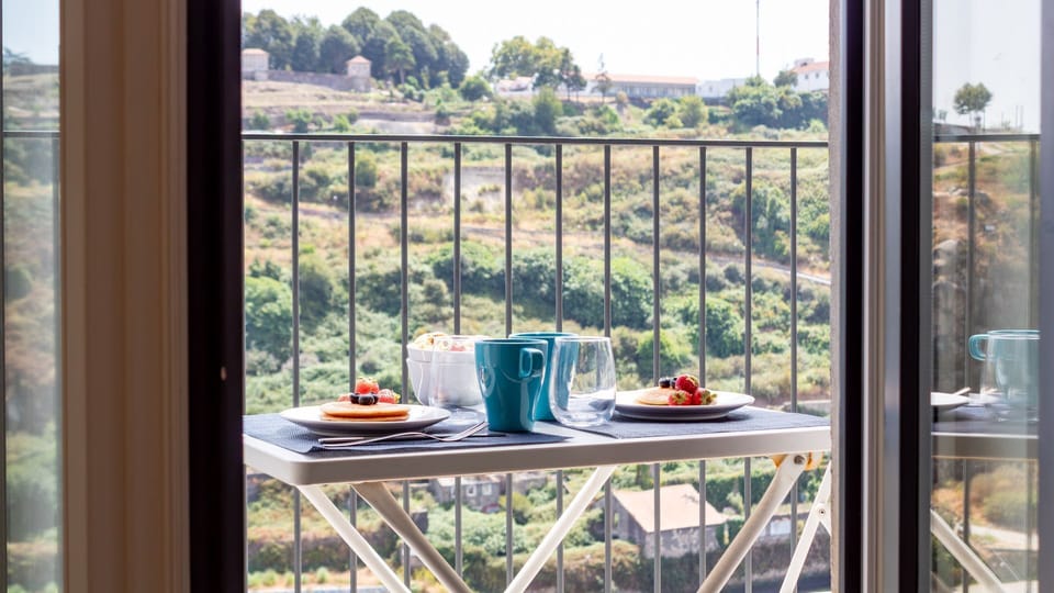 Savor your morning coffee or an evening drink on the charming private balcony, complete with a table and chairs, offering panoramic views of the lush green landscape. It's the perfect spot to unwind and soak in the tranquil surroundings.