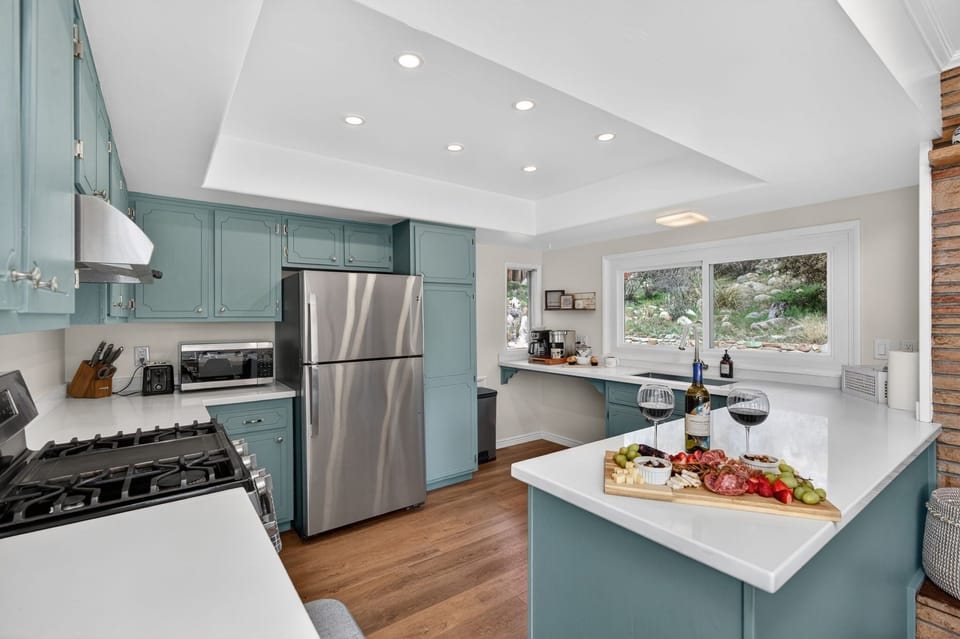 Fully equipped kitchen with modern appliances, quartz counters, and plenty of space for preparing meals.