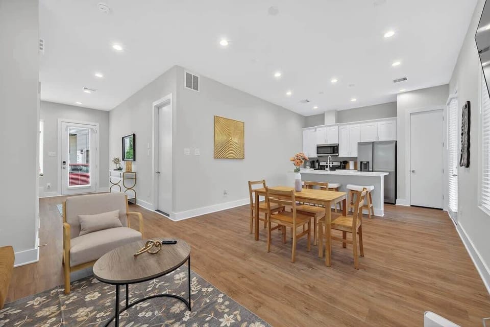 Bright open-concept living, dining & kitchen area with modern finishes, hardwood floors, full kitchen, and comfortable seating—perfect for relaxing, dining, or remote work.