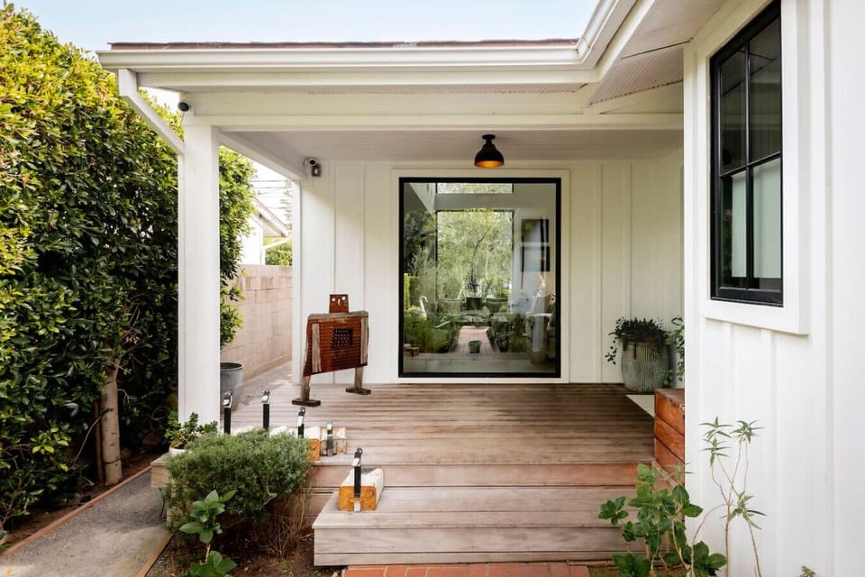 A shaded, private entry that sets the tone — greenery on all sides and a calm welcome home.