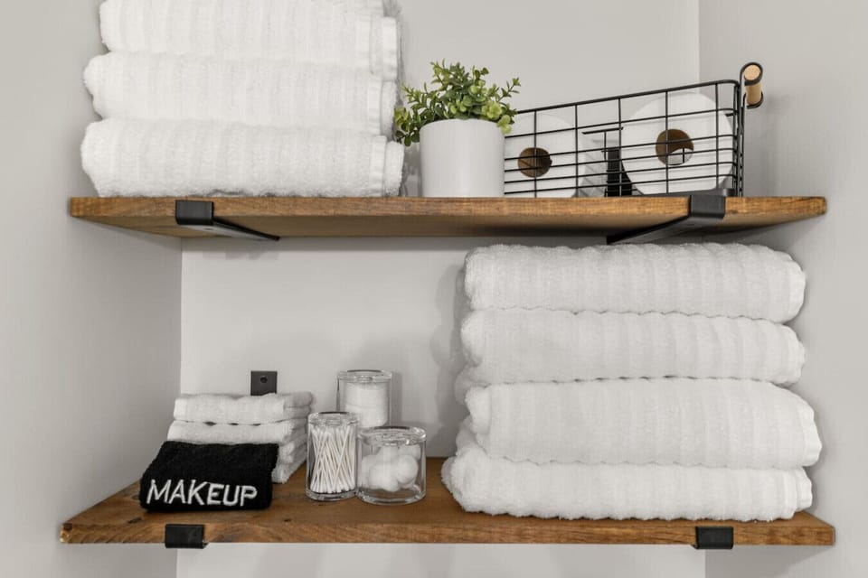 Spa‑inspired bathroom with fresh tile, a waterfall shower head, recessed toiletry cubby, and plush towels for a rejuvenating start or finish to your day.
