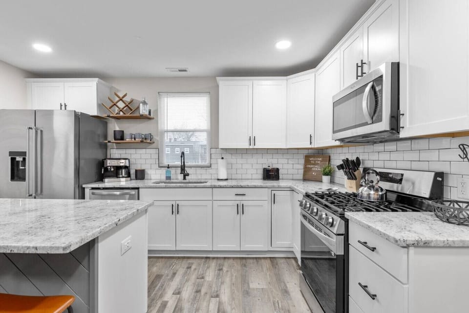 A fully equipped eat‑in kitchen built for effortless cooking and gathering, featuring a spacious island for four, a large basin sink, sleek appliances with an ice machine, and both espresso and drip coffee options to keep you peppy!
