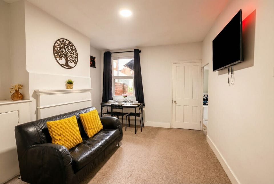 Open-plan living and dining space with a large Smart TV and dining table, all in one comfortable room.