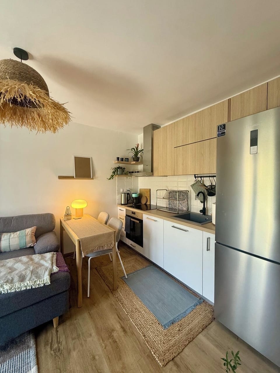 Cozy and bright living room with fully equipped modern kitchen and workspace.
