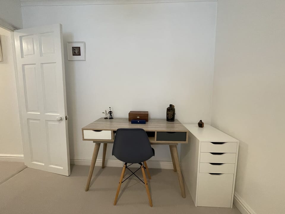 Comfortable double bedroom with a workspace & chest of drawers for storage