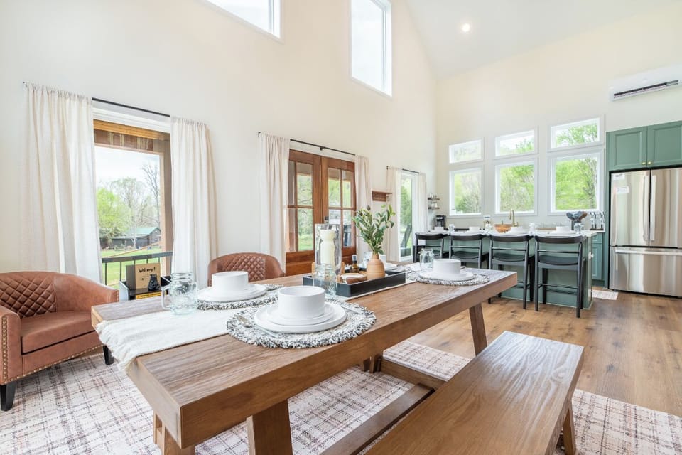 Your open-concept kitchen flows seamlessly into this bright dining space where morning coffee feels magical at the handcrafted wooden table.