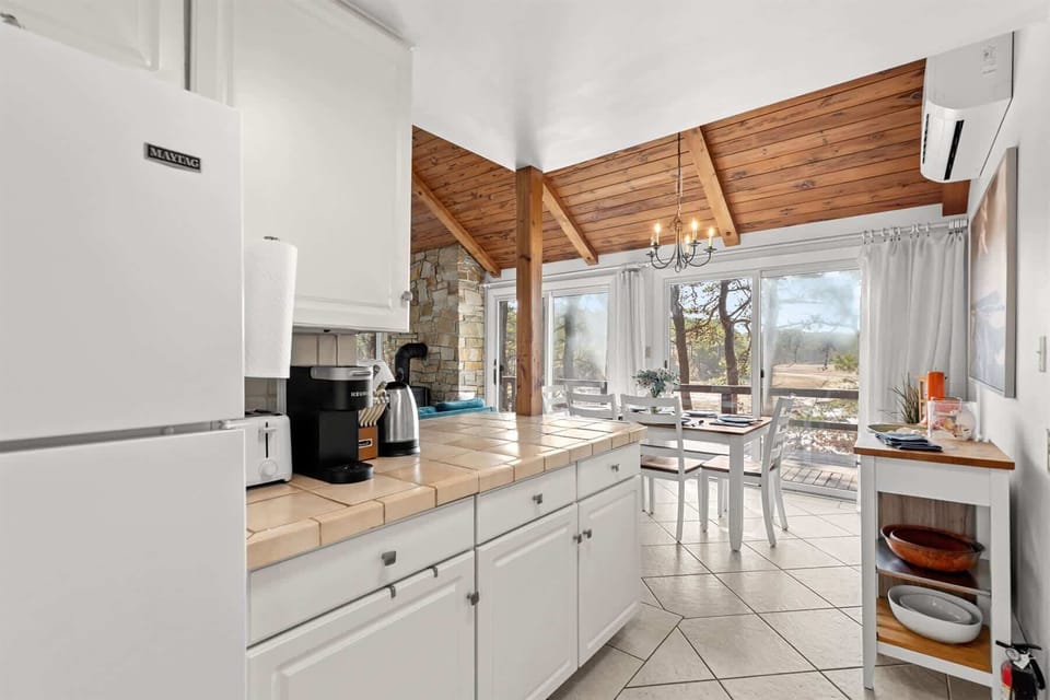 Kitchen view back toward the dining area and great room, highlighting the open layout and sunny marsh-facing windows.