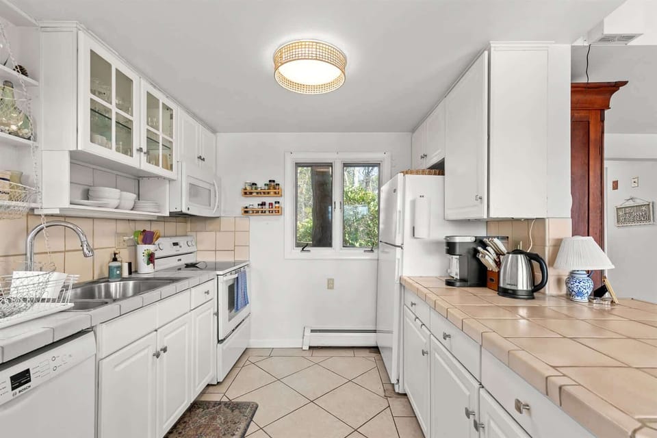Efficient galley kitchen with ample prep space, full appliances, and everything needed for easy Cape Cod vacation cooking.