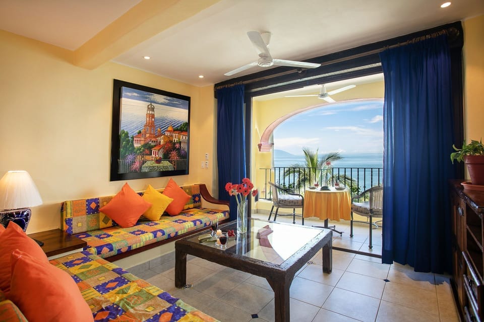 Step into the cozy living space adorned with vibrant Mexican-inspired decor and expansive views of the sea from the private balcony.