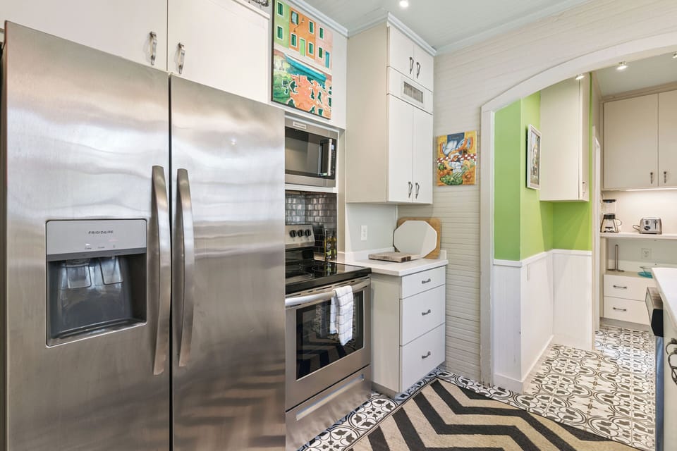 Your stylish kitchen features modern stainless steel appliances and colorful artwork, creating the perfect space for culinary adventures.