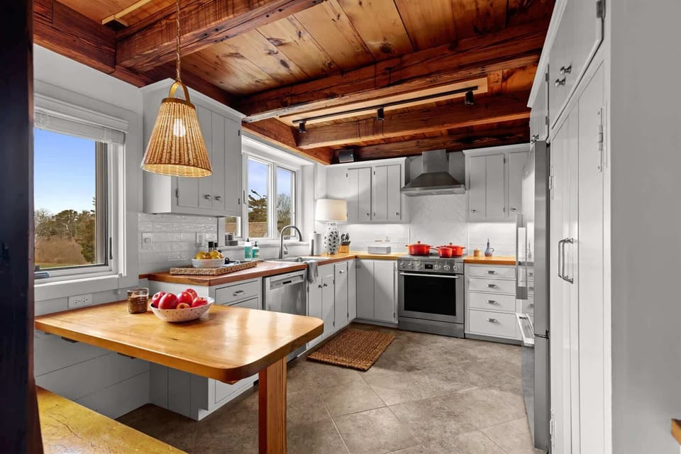 Bright chefs kitchen features stainless steel appliances, crisp cabinetry, warm wood counters, and classic Cape Cod charm throughout.
