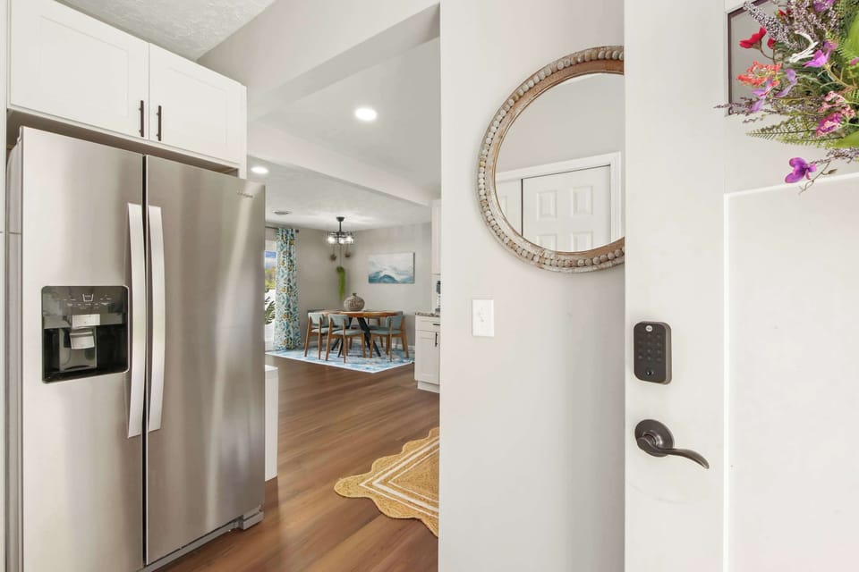 Sleek kitchen entry w/ stainless fridge & bright open layout throughout
