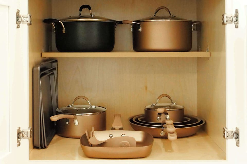 Neatly organized cookware cabinet ready for home-cooked meals together