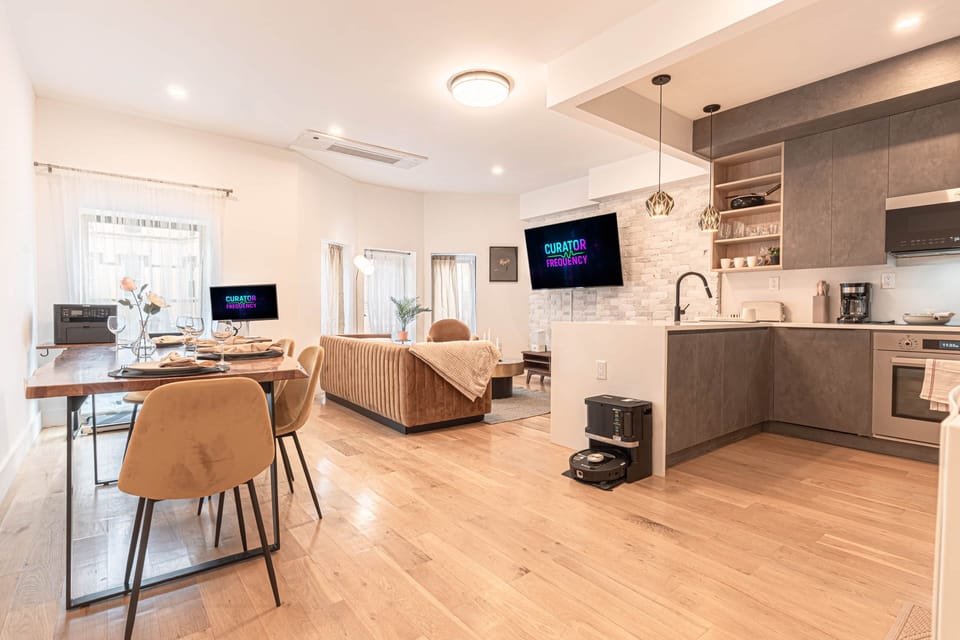 Open-concept space with modern kitchen, dining, and cozy living area
