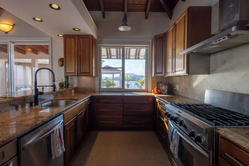 Fully equipped and beautifully designed for island living—perfect for morning coffee, shared dinners, or sunset cocktails. Enjoy stainless steel appliances, rich granite counters, and custom wood cabinetry that blend modern style with timeless charm.