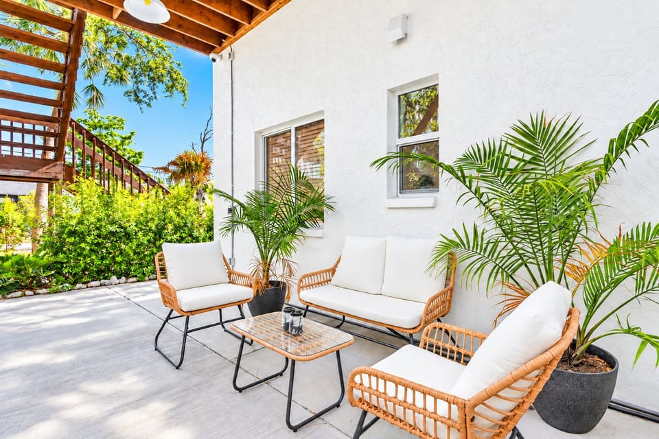 Sunny private patio with stylish seating and lush tropical greenery