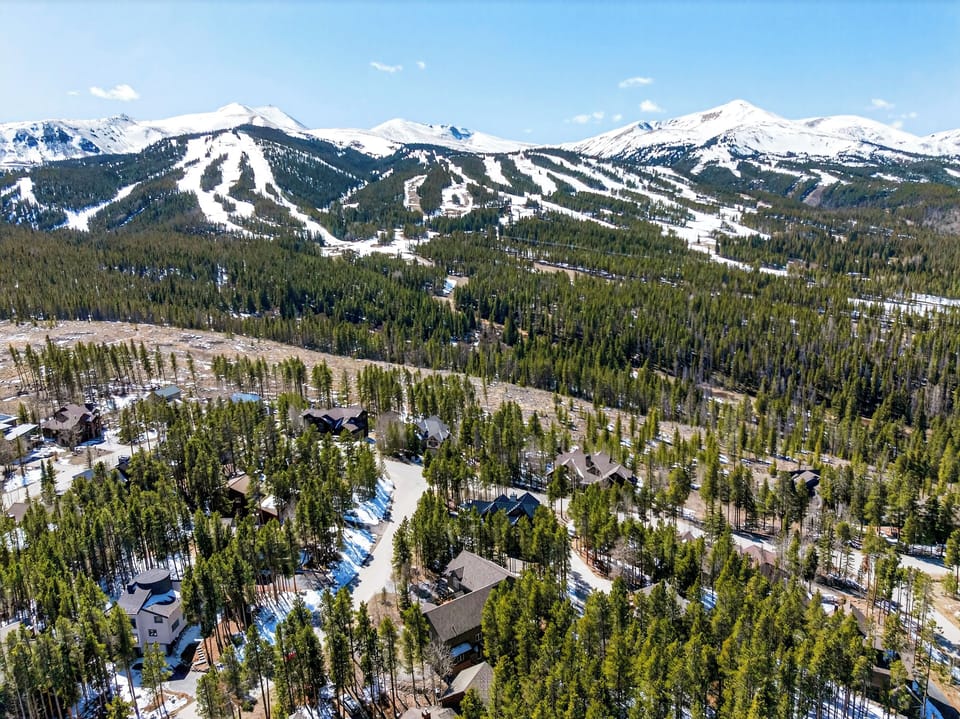 Aerial shot showing the cabin's proximity to the snowy ski runs.