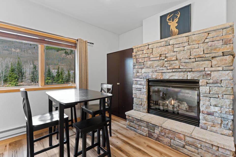 Dining table and gas fireplace with slope views.