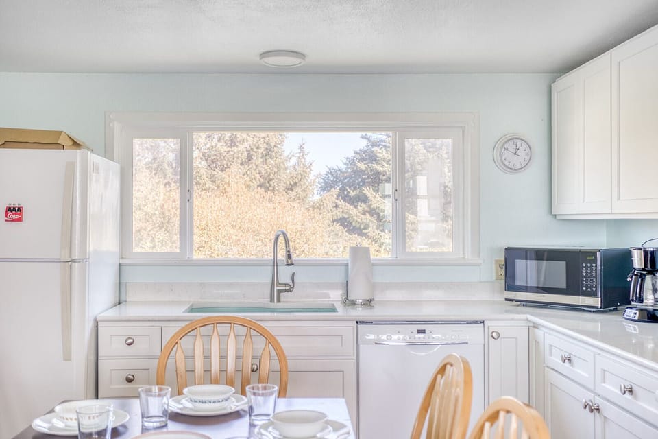 Cook your favorite meals in this bright, fully-equipped kitchen with garden views and modern appliances.