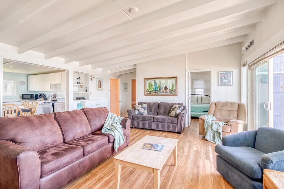 Relax in this spacious living room with exposed beam ceilings and warm hardwood floors, offering plenty of seating for your group.