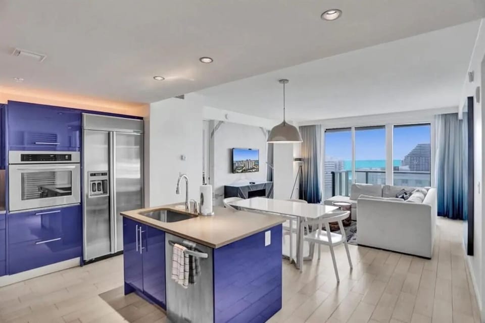 Spacious open kitchen and dining area with modern finishes and full appliances in this W Residences Fort Lauderdale Beach condo.