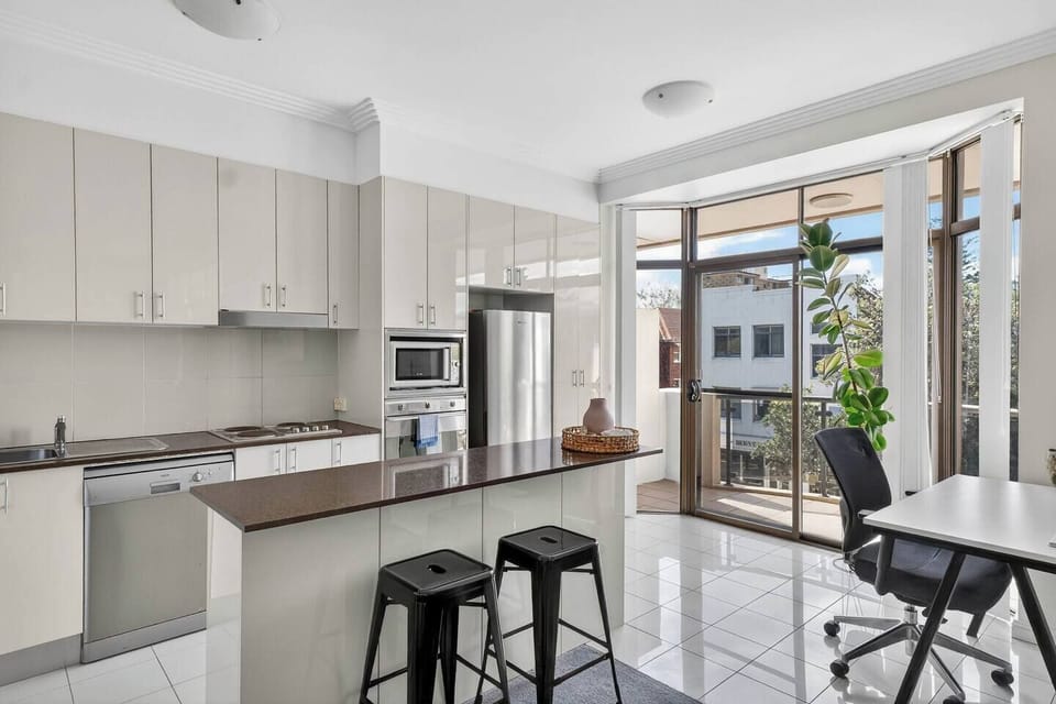 Cook with ease in the well-equipped kitchen, featuring an oven, dishwasher, microwave, and full-size fridge for effortless meals at home.