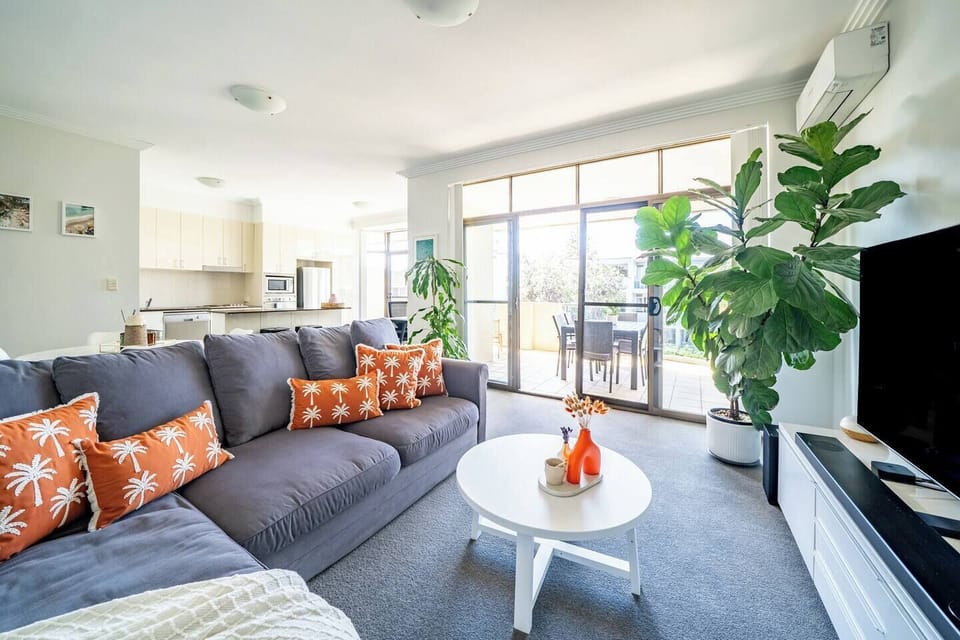 Settle into the light-filled living area, where comfortable seating and a TV create an easy place to unwind after a day at Bondi Beach.