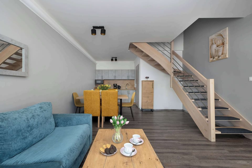 A perspective from the sofa highlights the transition from the lounge to the dining and kitchen areas, emphasizing the open layout.
