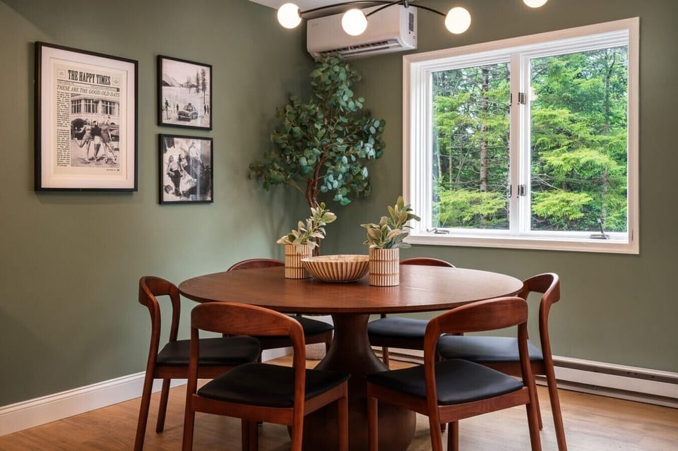 This breakfast nook seats six at a large round table, with vintage photos on the wall and a window bringing in plenty of natural light—an easy spot to start the day.