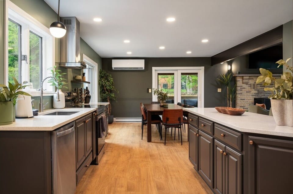 This kitchen keeps you close to the action—counters, sink, and oven within reach, with the dining table and screened porch doors just steps away for whoever`s on cooking duty.
