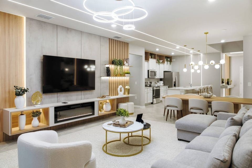 Enjoy the charm of this beautifully designed living area with a cozy gray sectional sofa and a chic coffee table, all set against warm wood accents and modern lighting for an inviting space to relax and connect with loved ones.