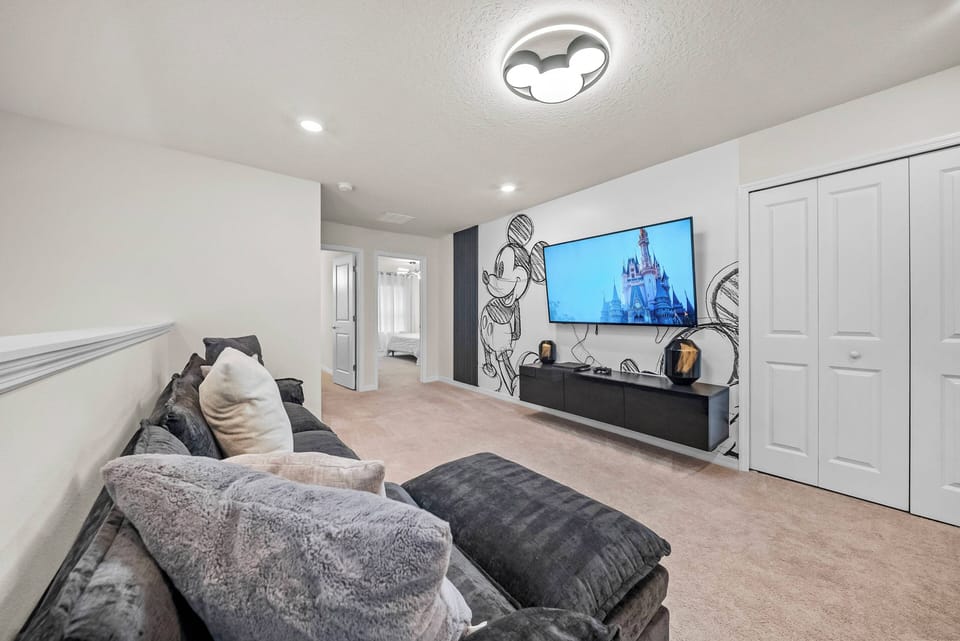 This cozy living area features soft, plush seating and a large flat-screen TV, perfect for movie nights. The neutral color palette and sleek cabinetry create a calm atmosphere, while the warm lighting adds a welcoming touch.
